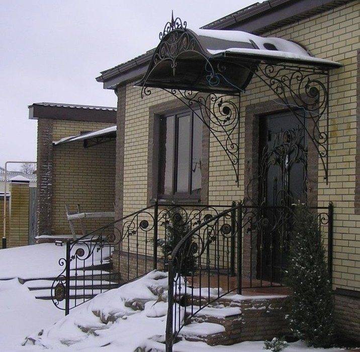 Wrought iron canopies over the porch endure winter as easily as summer