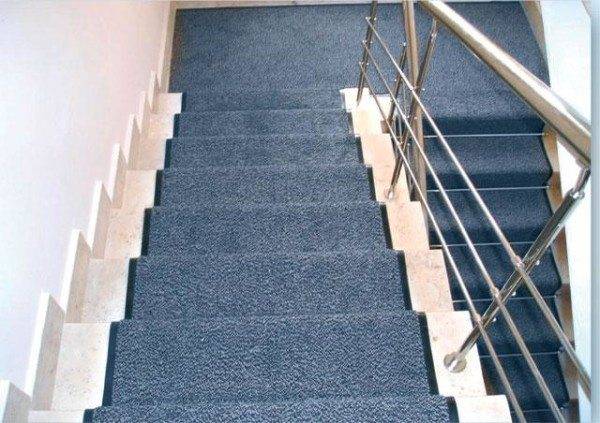 La photo montre que les tapis d'escalier, fixés avec de la colle, ont l'air soignés et s'adaptent bien aux marches.